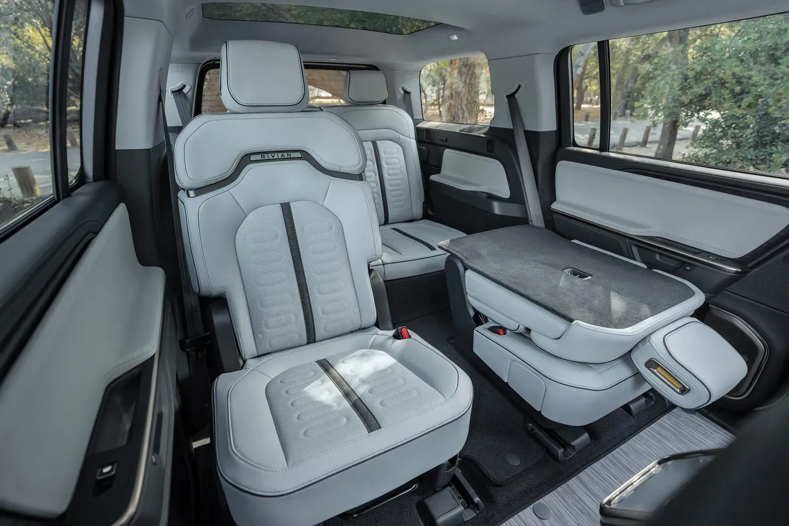 Fotele kierowcy modelu Rivian R1S z 2027 roku z przejściem pośrodku prowadzącym do trzeciego rzędu