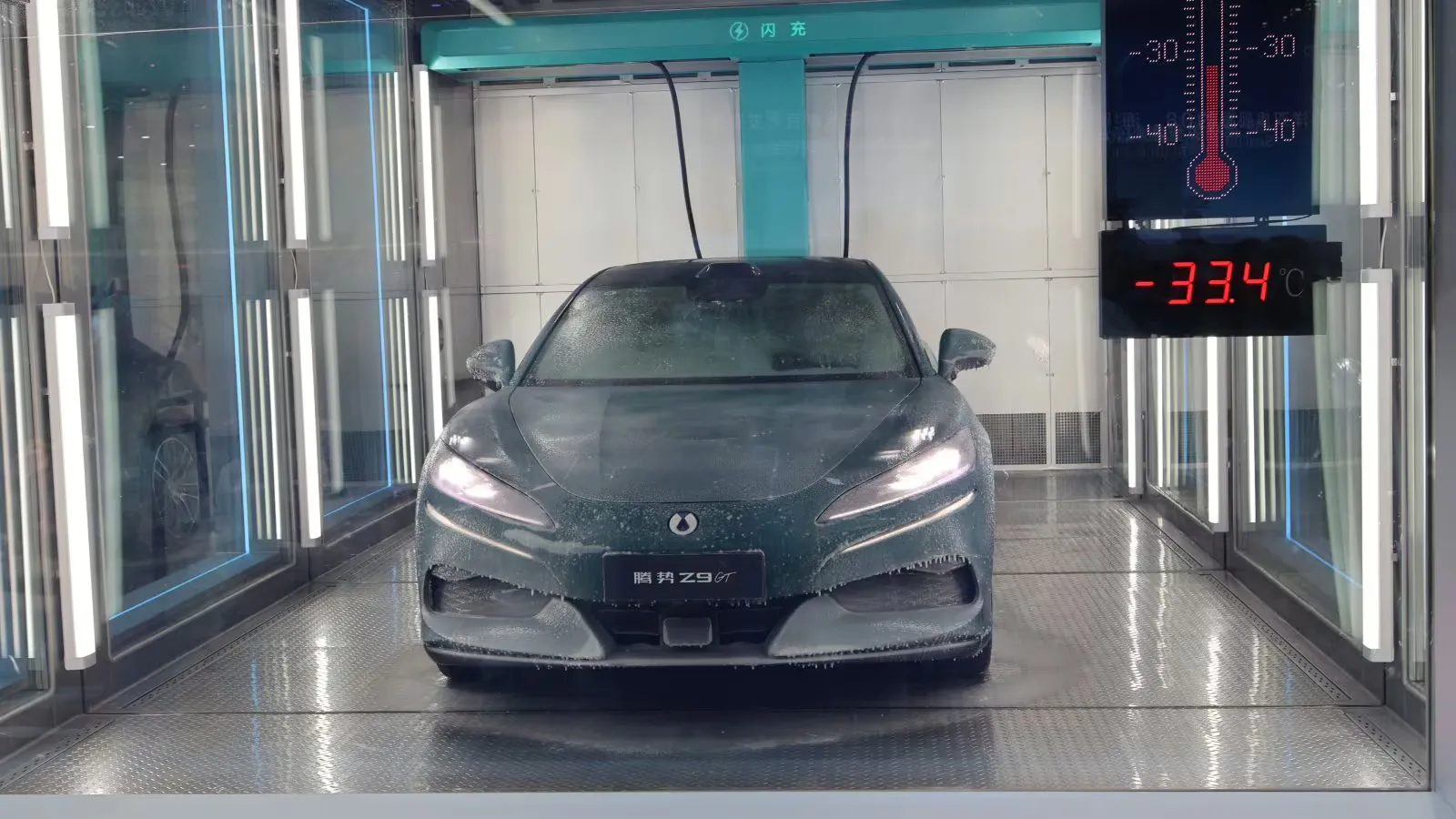 Um Denza Z9GT coberto de geada em uma câmara de demonstração de carregamento rápido, com um display mostrando 33,4 graus Celsius negativos.
