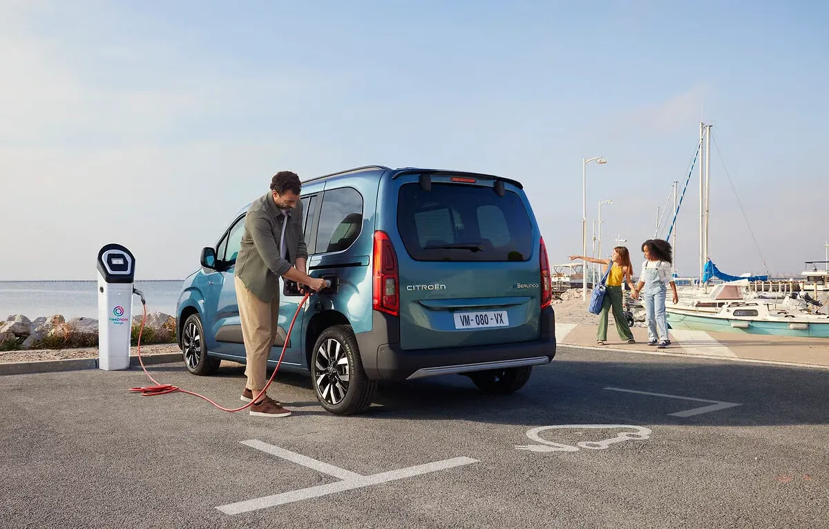 Motorista conectando um Citroën ë-Berlingo elétrico em uma estação de recarga pública