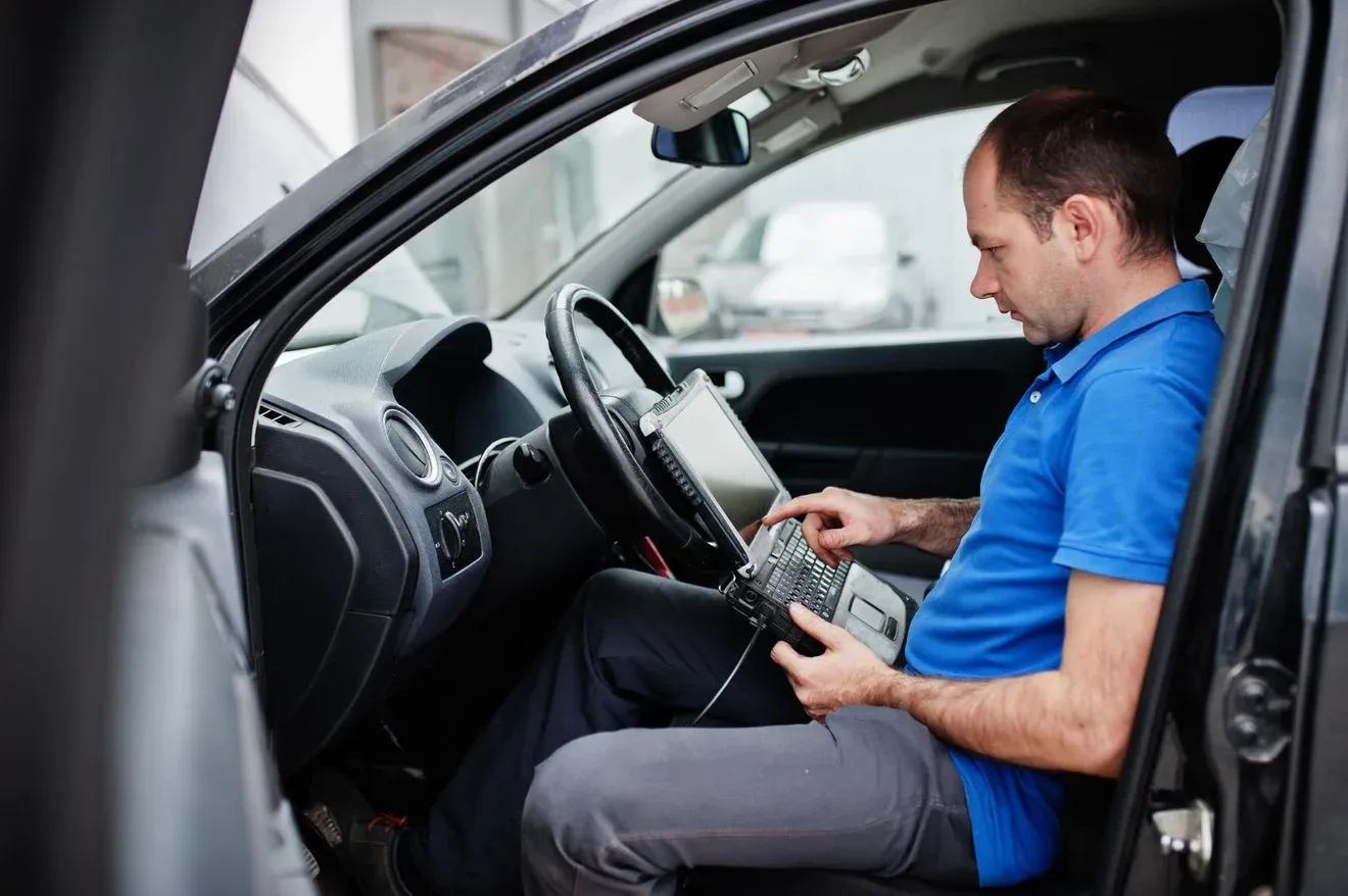 tema-reparacion-mantenimiento-automoviles-mecanico-electrico-uniforme-que-trabaja-servicio-automoviles-haciendo-diagnosticos-automoviles-usando-dispositivo-obd-computadora-portatil