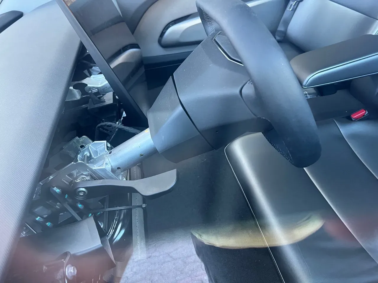 Exposed steering column and Cybertruck steering wheel bolted into a Tesla Cybercab prototype