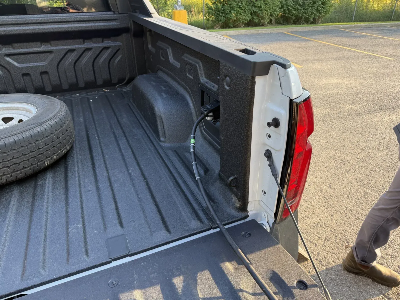 Power cable plugged into the bed outlet of a Chevy Silverado EV at the Saint-Henri concert