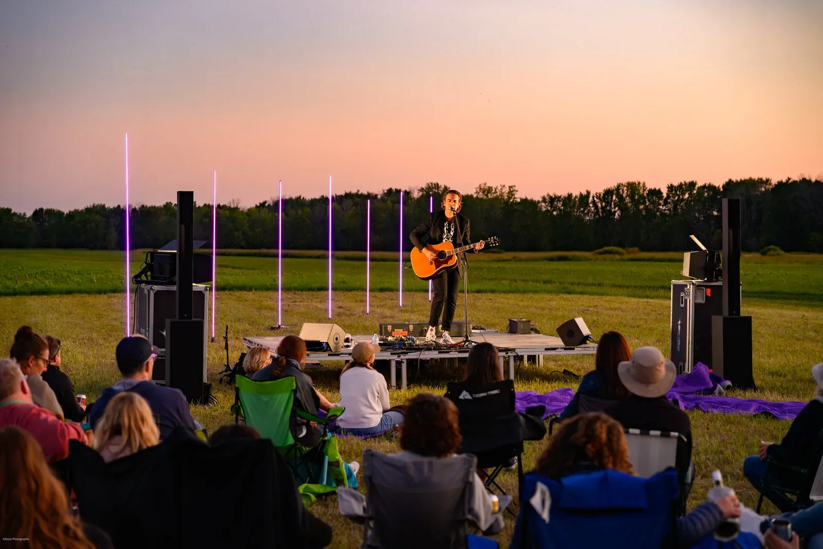Crowd watching a performance at sunset during the electric-powered concert tour