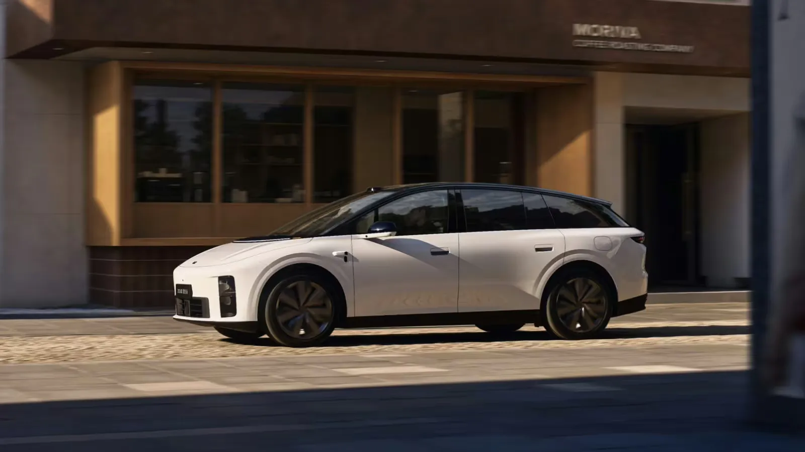 White 2026 Li i6 with a black roof on a street outside a cafe.