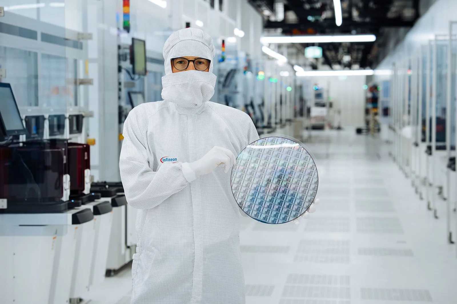 An Infineon cleanroom worker holds a 300 mm gallium nitride wafer in Villach, Austria.